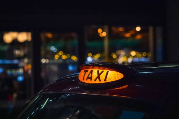 Illuminated taxi roof sign at night